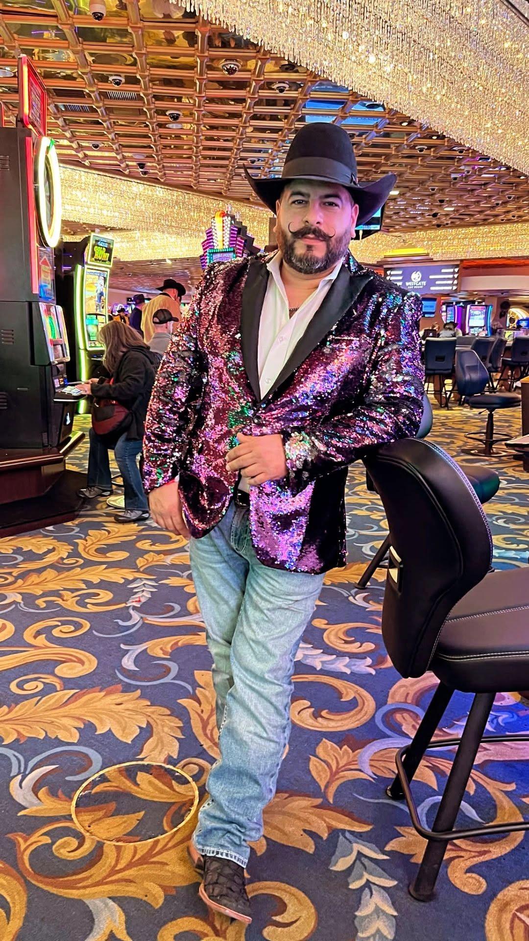 Tex Ruiz, owner of Take the Reins Western Wear, in a black felt cowboy hat and sequin jacket