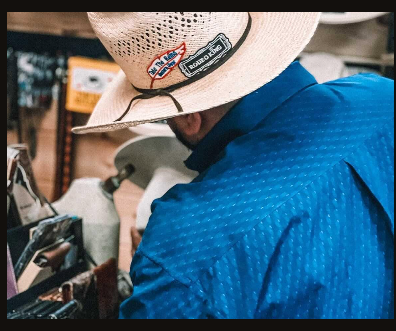 Tex Ruiz shaping a straw cowboy hat at the counter inside Take the Reins
